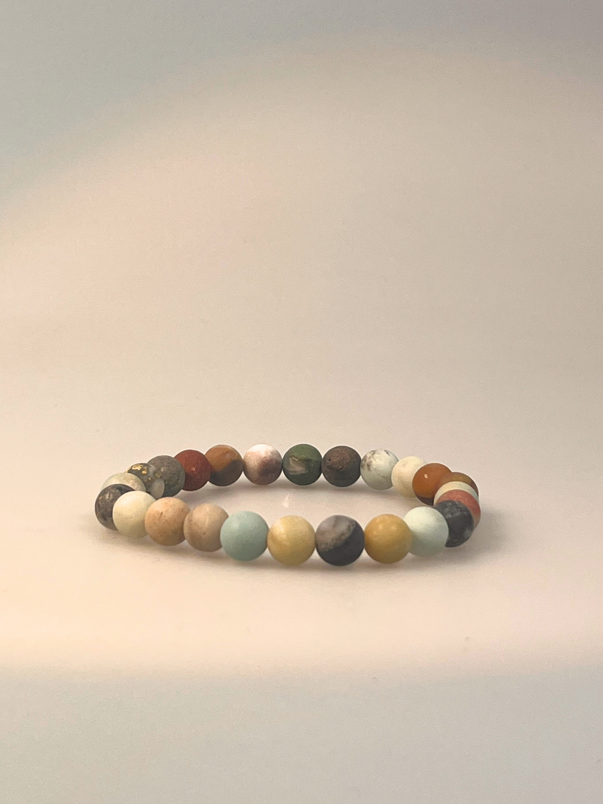 Ein elastisches Armband aus mattem Amazonit, bestehend aus gleichmäßig runden Edelsteinperlen in natürlichen Tönen von Hellgrün, Beige, Grau, Braun und sanften Blau-Nuancen. Das Armband ist freigestellt auf hellem Hintergrund dargestellt und wirkt erdend, beruhigend und vielseitig kombinierbar – ideal für Alltagsrituale oder als stilvolles Accessoire mit Bedeutung.