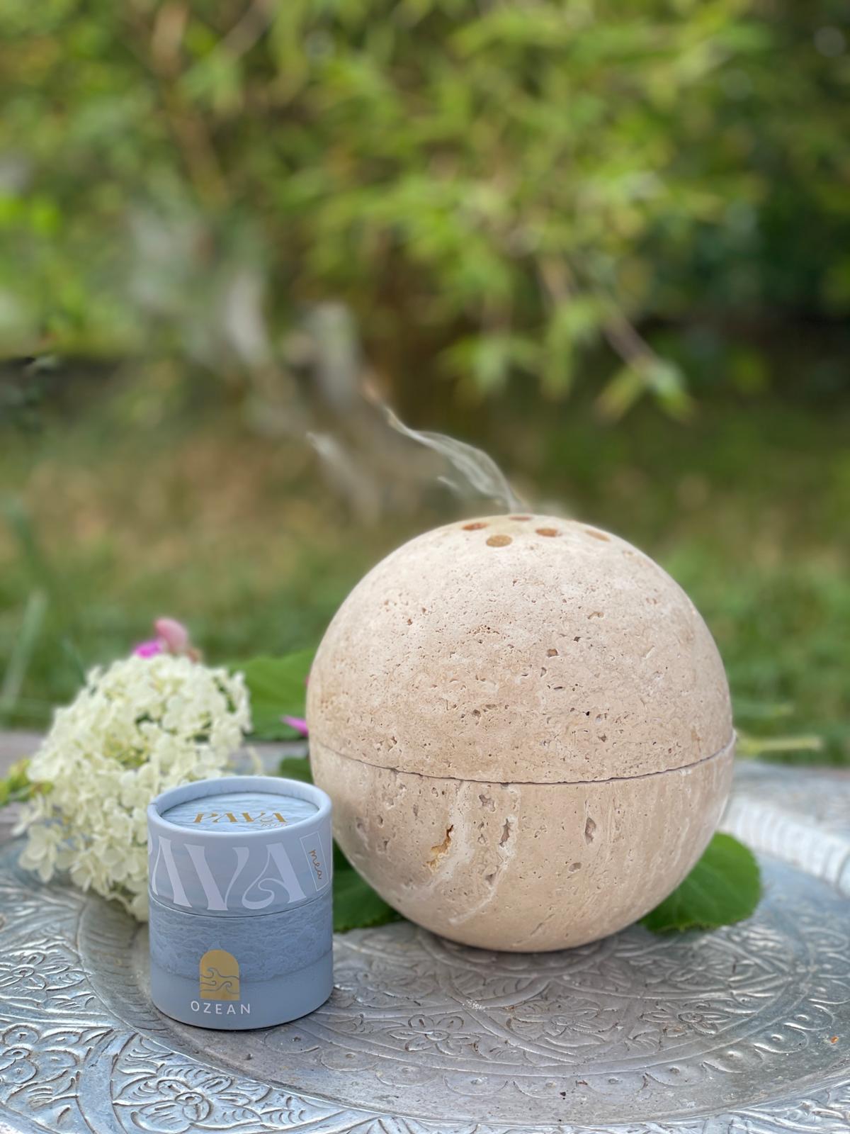 Räucherkugel PAVA SPHERA aus Travertin STein, die im Gartensteht und die Ozean Räuchermischung räuchert.