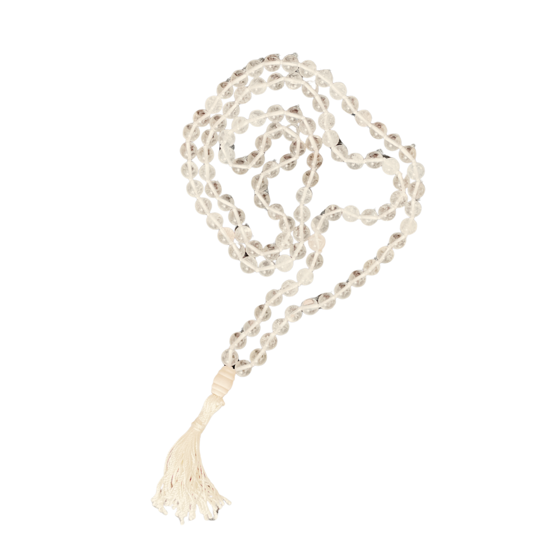 Filigrane Mala-Kette aus klaren, facettierten Bergkristallperlen – 108 Stück an der Zahl – kunstvoll auf einem hellen Band geknüpft. Die Kette ist locker geschwungen auf schwarzem Hintergrund arrangiert und wird durch eine cremefarbene Quaste abgerundet. Ideal für Meditation, Achtsamkeitspraxis oder als lichtvolles Schmuckstück mit klärender Ausstrahlung.