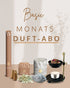 Abbildung des Basic Monats Duft-Abos von PAVA FUMA: ein harmonisch arrangiertes Set aus naturbelassenem Weihrauch, weißen Salbei-Bündeln, drei goldenen Räucherkegeln, einer Dose mit der Wasser-Räuchermischung, einer Packung Räucherstäbchen sowie einem schwarzen Siebstövchen mit Teelicht und Blüten. Alles vor stilisiertem, hellem Hintergrund mit edler Schrift.