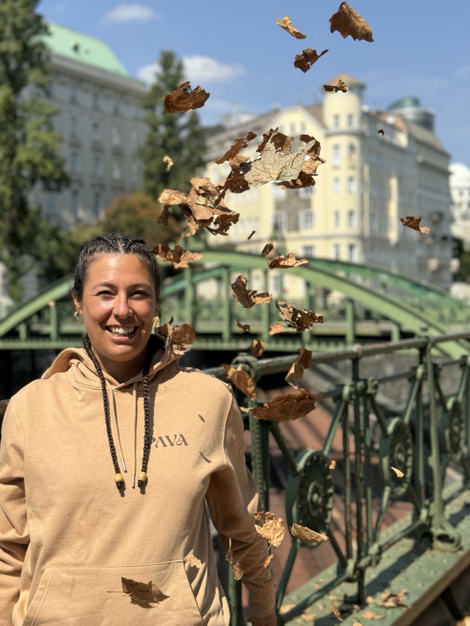 PAVA "Create Connection" Hoodie – Desert - warmer Desert-Ton, Vorderseite mit Pava-Logo, Kangurutsche, Kapuze mit Kordel. Bild zeigt eine Frau mit "Create Connection" Hoodie, PAVA "Create Connection" Hoodie – Desert - warmer Desert-Ton, Vorderseite mit Pava-Logo, Kangurutsche, Kapuze mit Kordel. Bild zeigt einen Mann mit "Create Connection" Hoodie, von vorne und draußen.