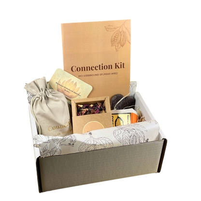 Eine geöffnete Geschenkbox mit dem Titel &quot;Connection Kit – Wo Verbindung spürbar wird&quot;, gefüllt mit Räuchermischung, Kakao, Ritualkarte, Anleitung, einem kleinen Beutel und weiterem Zubehör, liebevoll arrangiert auf bedrucktem Seidenpapier. Das Set wirkt hochwertig und eignet sich ideal für Rituale oder spirituelle Zeremonien.