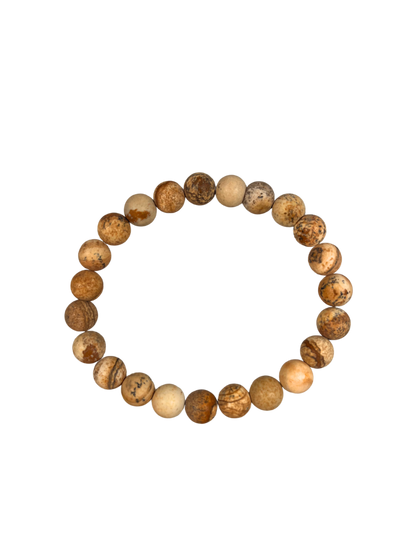Ein elastisches Armband aus Landschaftsjaspis mit matten, runden Perlen in warmen Erd- und Beigetönen. Jede Perle zeigt eine einzigartige Maserung mit natürlichen Linien und Mustern – von sandfarben bis ockerbraun. Das Armband liegt freigestellt vor hellem Hintergrund und vermittelt eine naturnahe, erdende Ausstrahlung – ideal für Achtsamkeit, Erdung und stilvolle Begleitung im Alltag.