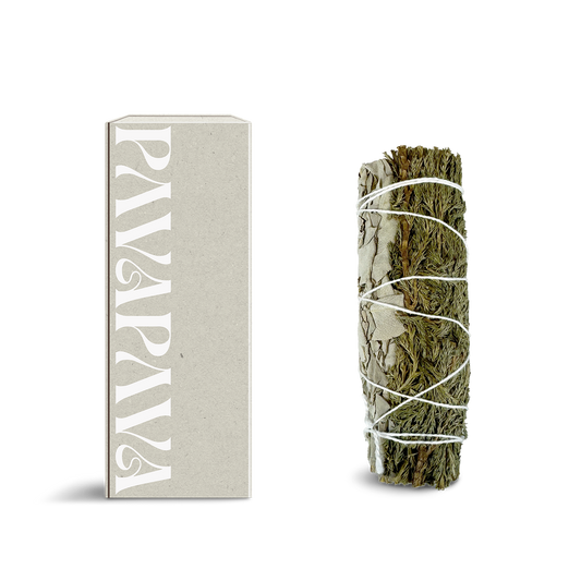 Weißer Salbei Räucherbündel von PAVAFUMA – rechts ein kompakt gebundenes Bündel aus silbrig-weißen Salbeiblättern, traditionell verschnürt für achtsames Räuchern. Links daneben eine minimalistische, hochwertige Verpackung in hellem Naturton mit vertikalem PAVAFUMA-Schriftzug. Ideal für energetische Reinigungsrituale, Hausreinigung und Meditation – der intensive, krautige Duft klärt die Atmosphäre und unterstützt bewusste Übergänge.