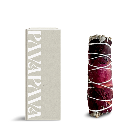 Weißer Salbei mit Rosenblüten von PAVAFUMA – links die hochwertige, minimalistisch designte Verpackung in Naturtönen mit vertikalem PAVAFUMA-Schriftzug. Rechts daneben das kunstvoll gebundene Räucherbündel aus weißem Salbei, umhüllt von intensiven, tiefroten Rosenblättern. Ideal für energetische Hausreinigungen, Herzöffnung und besondere Rituale – eine stilvolle Kombination aus klärender Reinigung und floraler Duftnote.